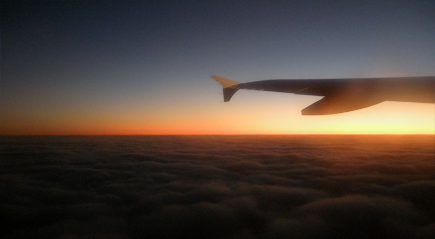 View of setting sun and horizon from plane