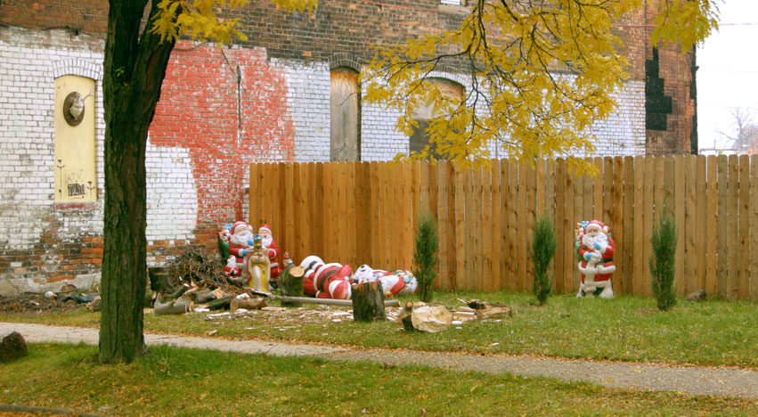 Deserted Santa Claus figures along fence