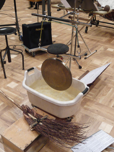 Small plastic bathtub on wheels with a gong hanging above