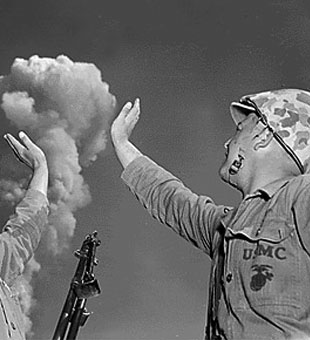 Two U.S. Army soldiers high five an atomic mushroom cloud.
